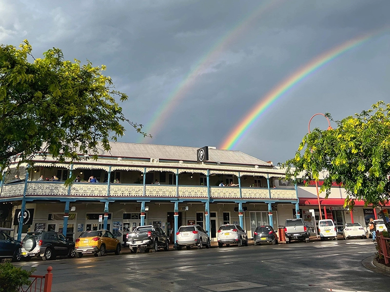 Photo of the Hotel from the street with a double rainbow behind